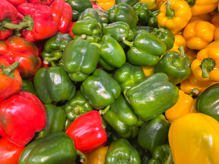 Naklejka na ściany i meble Lots of raw green, red, yellow Bell pepper close up at the market. Fresh organic vegetables in the supermarket. Harvest concept