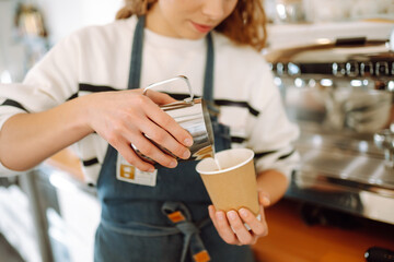 Barista girl preparing deliciouse fresh hot coffee in professional coffee machine. Takeaway food.