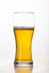 Pint of beer, ale, lager on white background half empty