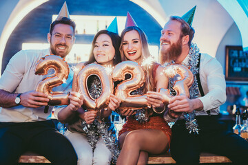 women and men celebrating the new year 2023 with wine