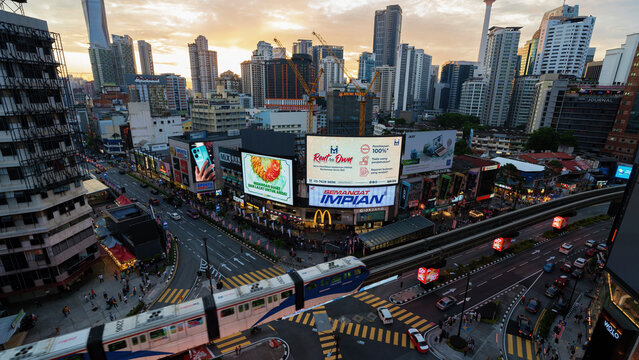 KL, MALAYSIA - Sept 26th, 2022 : image of high angle view of the pedestarian crowd crossing Bukit Bintang intersection and the passing by monorel in the heart of Kuala Lumpur downtown.