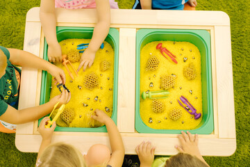 Top view of children with kinetic sand. Hand of little kid