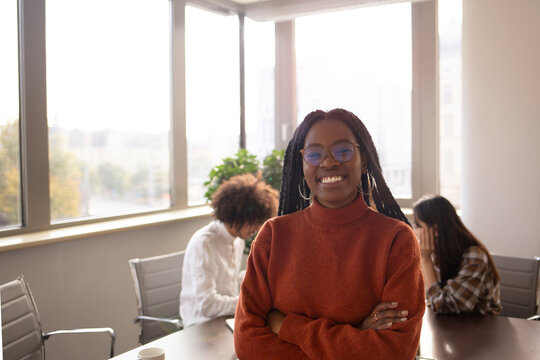 Black girl in foreground is taking a break in the office