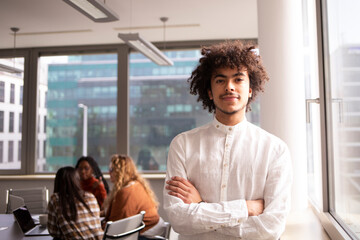 Young man in the office is looking at the camera