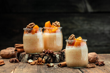 Creamy dessert with pumpkin mousse on a wooden background. place for text.
