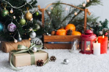 Christmas gift with tags for writing. In the background is a Christmas tree and gifts with lights. New year background.