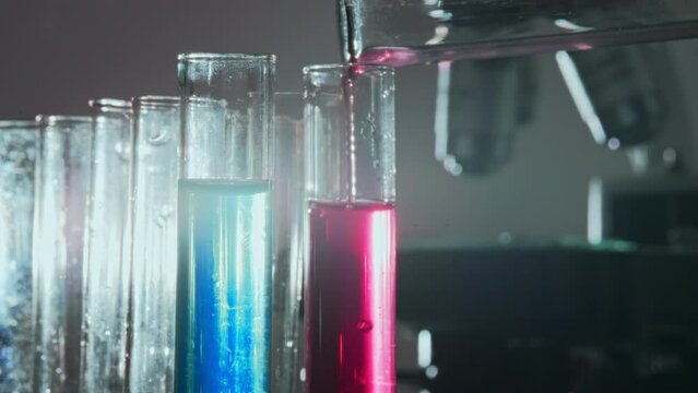 Pouring liquid into laboratory test tubes.