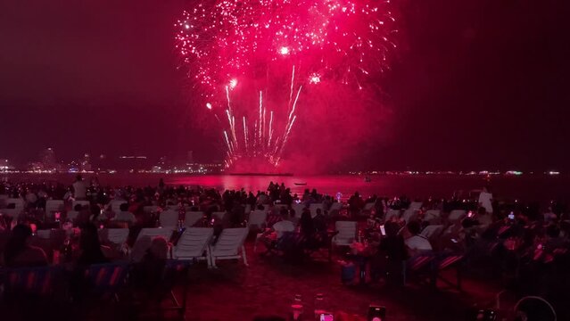 Pattaya, Thailand - Circa November, 2022 : Fireworks show at Pattaya Fireworks Festival at night. View of people gathered on beachfront enjoy and watch incredible fireworks. Celebration concept