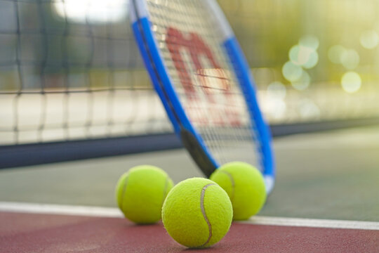 Wilson Tennis Racket And Balls On Court