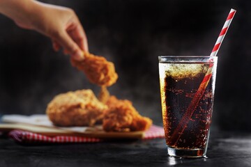 Close up A glass of fizzy soft drink over chicken wings dish background - obrazy, fototapety, plakaty