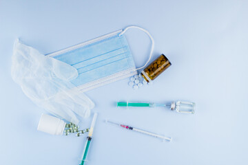white medical protective glove, medical mask, syringe with needle, vaccination, vial and pills....