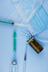 white medical protective glove, medical mask, syringe with needle, vaccination, vial and pills....