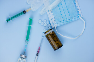 white medical protective glove, medical mask, syringe with needle, vaccination, vial and pills....
