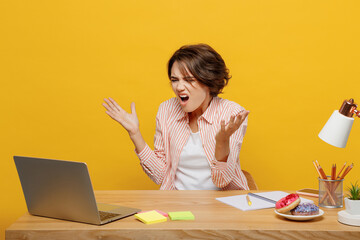 Young mad angry wondered employee IT business woman in casual shirt sit work at office desk using...