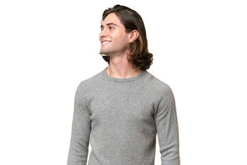 Fototapeta premium Young caucasian man isolated on green chroma background looking side