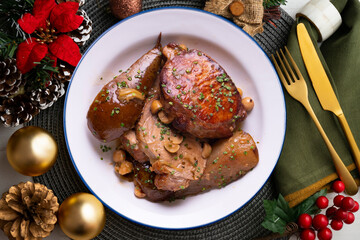Low temperature cooked pork loin with pears on a decorated table on Christmas week. Typical Spanish tapa recipe.