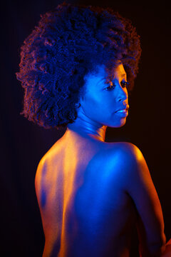 Naked black woman under neon light