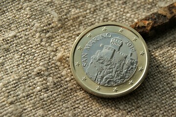 San Marino 1 euro coin on natural linen fabric.