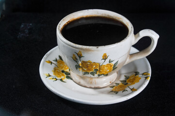 cup of black coffee on black background