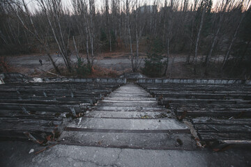 Abandoned stadium in the city of Pripyat, rotten benches of spectators, Chernobyl region, exclusion...