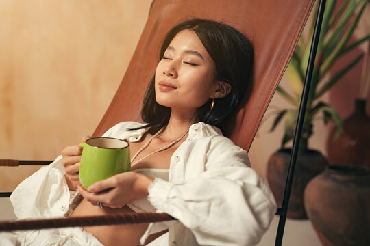 Close-up Of Korean Woman Having Rest After Work Enjoying Relaxing Herbal Tea And Silence