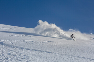 Freeride snowboarder goes downhill in deep snow