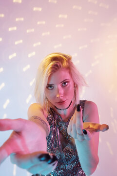 Attractive blond woman wearing boujee dress and accessories inviting to dance portrait