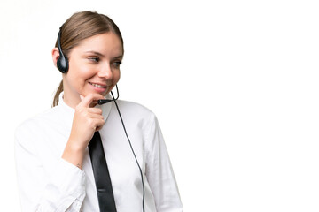 Telemarketer caucasian woman working with a headset over isolated background thinking an idea and looking side