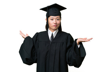 Young university graduate Asian woman over isolated background having doubts while raising hands