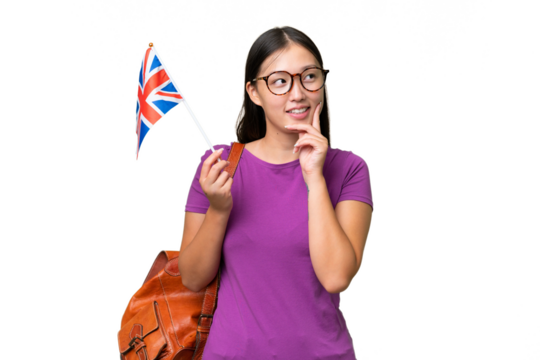 Young Asian woman holding an United Kingdom flag over isolated background thinking an idea while looking up