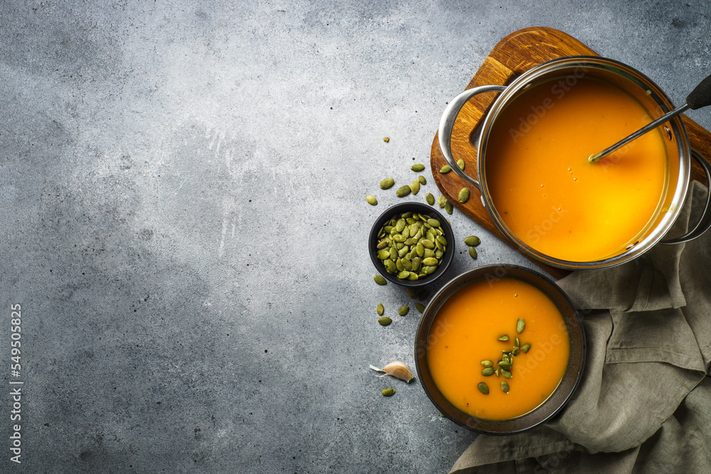 Wall mural pumpkin soup in the pot at stone table. top view with copy space.