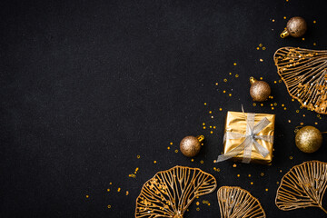 Christmas flat lay background with golden holiday decorations. Top view on black with copy space.