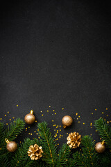 Christmas flat lay background with golden holiday decorations on black. Top view with copy space.