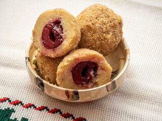 sweet plum dumplings made of leavened dough and fresh plums on clay bowl