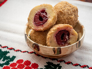 sweet plum dumplings made of leavened dough and fresh plums on clay bowl