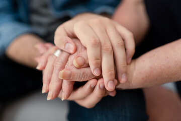 The hands of a teenage boy on the wrinkled hands of an older woman. Concept of care for the elderly.