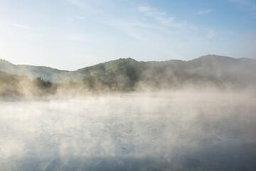 Foggy lake at dawn sunrise