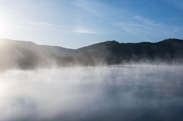 Foggy lake at dawn sunrise