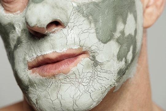 Unrecognizable man with blue clay mask drying on his face beauty macro shot