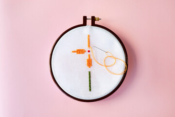 Floral pattern on canvas. Cross stitch technique. Hobby, handmade home decor concept. DIY.