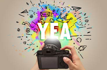 Close-up of a hand holding digital camera with abstract drawing