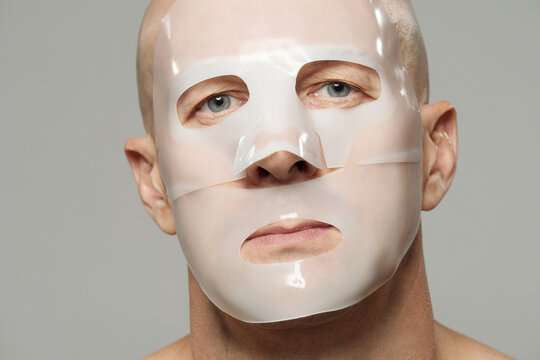 Mature man using moisturising hydrogel collagen mask on face