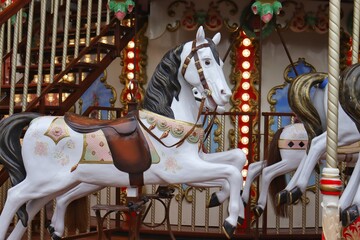 A white horses on a carousel in the park. 