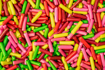 many colored marmalade candies laid out on a flat surface; dessert for the holiday; sweet gifts for children; texture and background with small candies