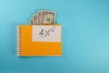 note in an orange sketchbook with the text 4 percent over a bluebackground