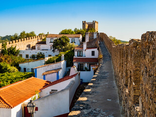 Fototapeta na wymiar Stunning medieval walls surrounding the whitewashed houses of Obidos village, Oeste Region, Portugal 