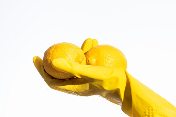 a hand in a rubber glove holds a yellow lemon, natural cleaning products for home and kitchen, professional cleaning