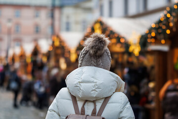 Woman with knit hat looking at christmas market stall on city square