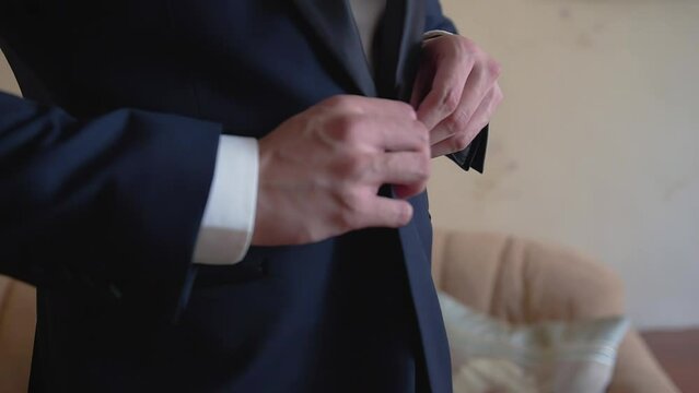 A man is buttoning his jacket going to a meeting. Side-by-side close-up