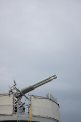 A double-barreled anti-aircraft gun on a historic warship. Photo taken on a cloudy day, soft light